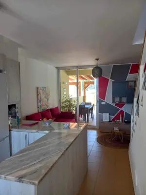 a kitchen with a counter and a living room at Charming Beach Villa Porto Santo in Porto Santo