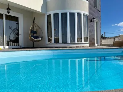 a swimming pool in front of a house at Slice of Ponta do Sol - Suite 2 in Canhas