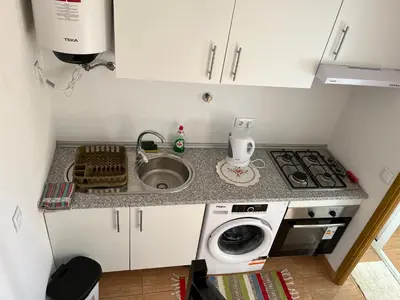 a small kitchen with a sink and a washing machine at Slice of Ponta do Sol - Suite 2 in Canhas