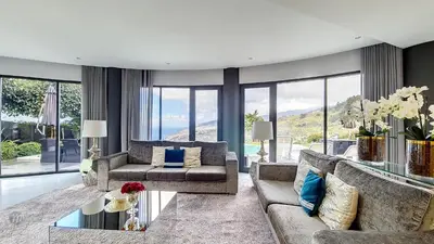 a living room with a couch and a table at Villa Bonsai in Arco da Calheta