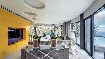 a living room with a table and a tv at Villa Bonsai in Arco da Calheta
