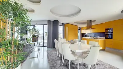 a dining room with a white table and white chairs at Villa Bonsai in Arco da Calheta
