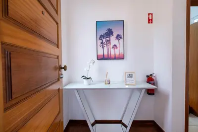 a hallway with a white console table next to a door at Sol&mar in Ponta do Sol