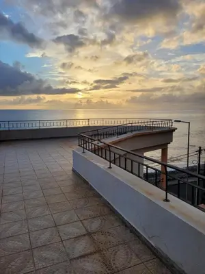 a pier with a sunset over the water at Sol&mar in Ponta do Sol