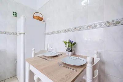 a kitchen with a wooden table with a white refrigerator at Sol&mar in Ponta do Sol