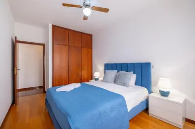 a bedroom with a blue bed and a wooden cabinet at Sol&mar in Ponta do Sol