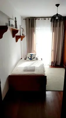 a bedroom with a bed and a large window at Apartamento do Corpo Santo in Funchal