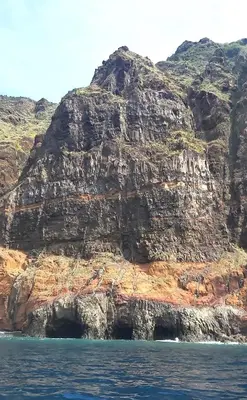 a rocky mountain with a cave in the water at Apartamento do Corpo Santo in Funchal