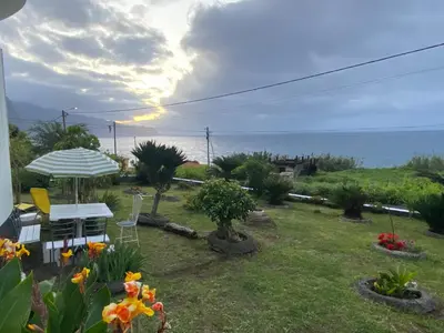 a bedroom with a bed and a sliding glass door at Ocean Garden, 4 units by the ocean in São Vicente