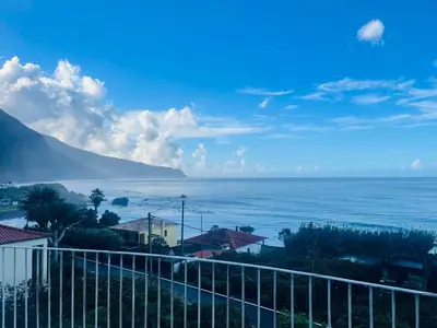 a garden with a table and chairs and flowers at Ocean Garden, 4 units by the ocean in São Vicente