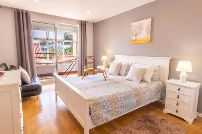 a bedroom with a white bed and a window at Maria Casa Branca by ALMA Holiday Rentals in Funchal
