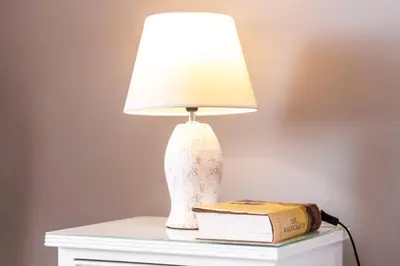 a lamp sitting on top of a table with a book at Maria Casa Branca by ALMA Holiday Rentals in Funchal