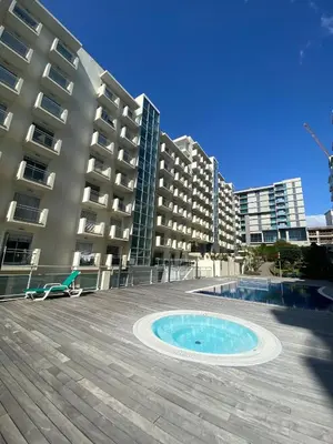 a swimming pool in front of a large building at Concordia Apartment in Funchal