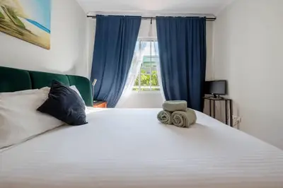 a bedroom with a large white bed with blue curtains at Unique Two-Patios - Stylish Stay by Pico Fortress in Funchal