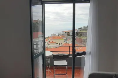 a view of a balcony with a table and chairs at Pedreira apartment in Calheta
