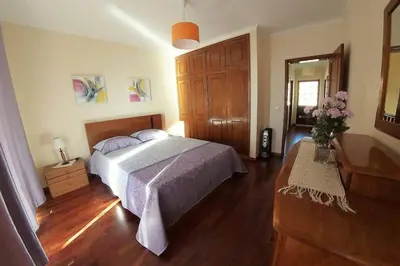 a bedroom with a bed and a wooden floor at Benoni House by Stay Madeira Island in Ponta do Sol