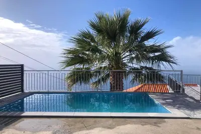 a backyard with a pool and chairs and a house at Villa Rosa with private pool by Holiday Rental Madeira in Ribeira Brava