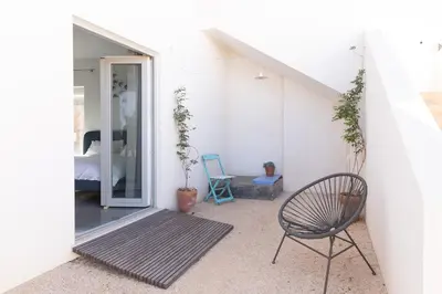 a room with a chair and a door to a bedroom at Moinho Calmo in Vila do Bispo