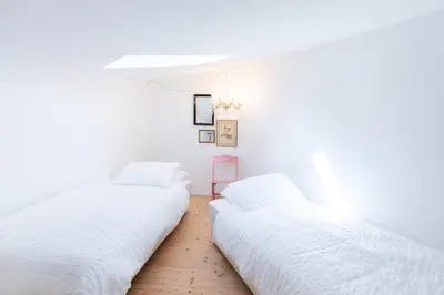 two beds in a room with white walls at Moinho Calmo in Vila do Bispo