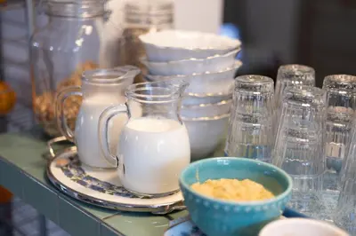 a table with glasses and a bowl of milk at Moinho Calmo in Vila do Bispo