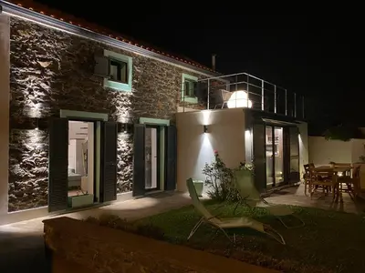 a house at night with chairs in front of it at The Hideaway Madeira in Prazeres