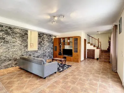 a living room with a couch and a stone wall at Vila Feliz in Paul do Mar