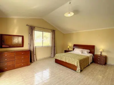 a large bedroom with a bed and a window at Vila Feliz in Paul do Mar