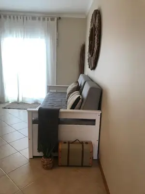 a bed in a room with a suitcase next to a window at Cool Apartment in Porto Santo
