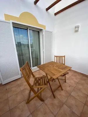 a wooden table and two chairs on a patio at Cool Apartment in Porto Santo