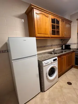 a kitchen with a white refrigerator and a washing machine at Cool Apartment in Porto Santo