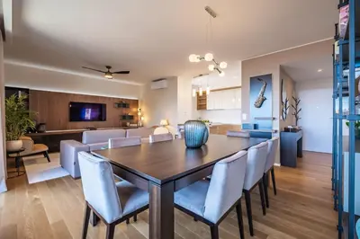 a dining room and living room with a table and chairs at Maha by KAAMAH - 2 Bedroom OceanView Designer Apartment in Funchal