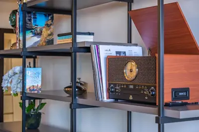 a shelf with a radio and books on it at Maha by KAAMAH - 2 Bedroom OceanView Designer Apartment in Funchal