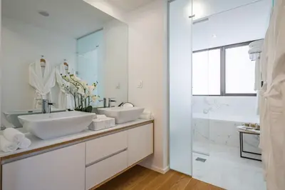 a white bathroom with two sinks and a shower at Maha by KAAMAH - 2 Bedroom OceanView Designer Apartment in Funchal