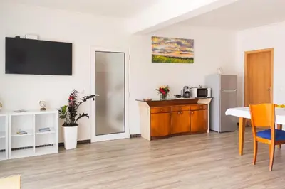 a living room with a table and a kitchen at Casa Luz - Arco da Calheta in Arco da Calheta