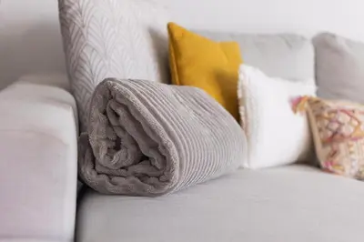 a towel sitting on a couch with pillows at Casa Luz - Arco da Calheta in Arco da Calheta