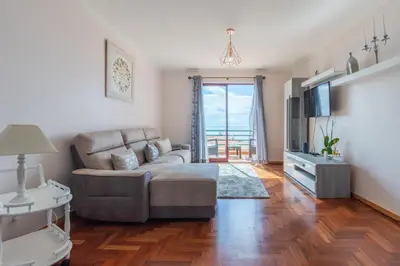 a living room with a couch and a television at Calandiva in Caniço