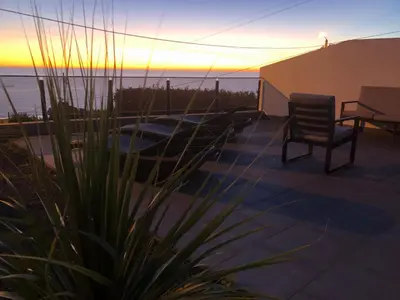 a patio with a chair and a view of the ocean at Calheta Ocean View Apartment 2 - Air Condition in Estreito da Calheta