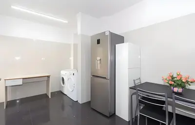 a kitchen with a refrigerator and a table with flowers on it at Praia Mar (sea view) by STAY Madeira Island in Ponta do Sol