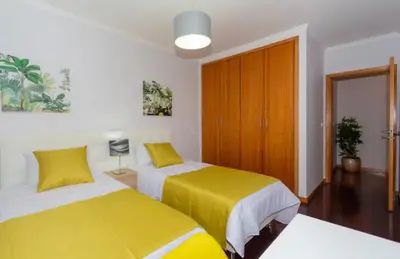 two beds in a room with yellow sheets at Praia Mar (sea view) by STAY Madeira Island in Ponta do Sol