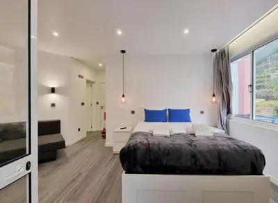a kitchen with white cabinets and a white door at The Jolie - Apartments by the Ocean in Porto Moniz