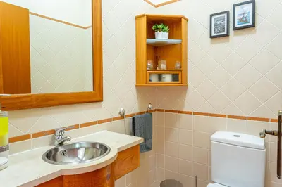 a bathroom with a sink and a toilet and a mirror at Lobos Flat in Câmara de Lobos