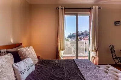 a bedroom with a bed and a large window at Lobos Flat in Câmara de Lobos