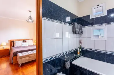 a bathroom with a tub and a bedroom with a bed at Lobos Flat in Câmara de Lobos