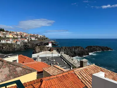 a view of a town and the ocean with buildings at Casa do Ilhéu - House of Ilhéu - Câmara de Lobos in Câmara de Lobos