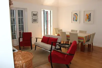 a living room with a dining room table and chairs at Casa do Ilhéu - House of Ilhéu - Câmara de Lobos in Câmara de Lobos