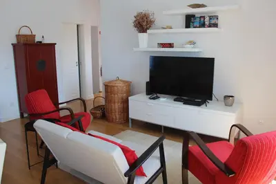 a living room with red chairs and a flat screen tv at Casa do Ilhéu - House of Ilhéu - Câmara de Lobos in Câmara de Lobos