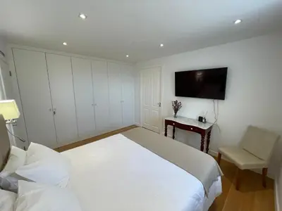 a bedroom with a bed and a desk and a tv at Casa do Ilhéu - House of Ilhéu - Câmara de Lobos in Câmara de Lobos