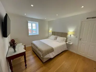 a bedroom with a white bed and a television at Casa do Ilhéu - House of Ilhéu - Câmara de Lobos in Câmara de Lobos