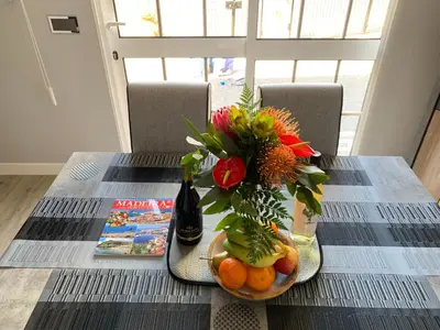 a table with a vase of flowers and fruit on it at Funchal Apt- Sleeps 2 - Pool & Parking - Madeira in Funchal