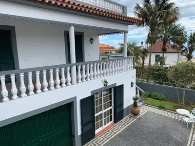a white house with a gate and a balcony at Funchal Apt- Sleeps 2 - Pool & Parking - Madeira in Funchal